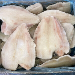 Pescados de limanda calamares congelados en bloque a la venta en el mercado de pescado, dispuestos en una caja y en una bolsa en una bolsa azul
